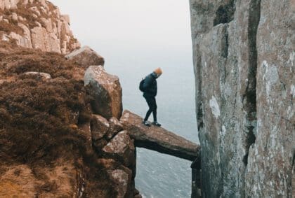 Mann wagt sich auf einen vorspringenden Felsen